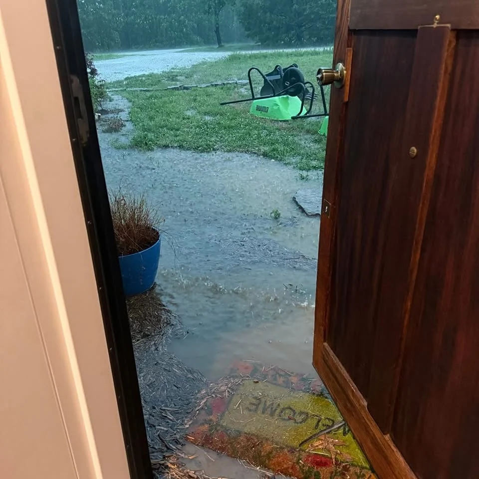 Severe residential flooding at a doorway before drainage improvements