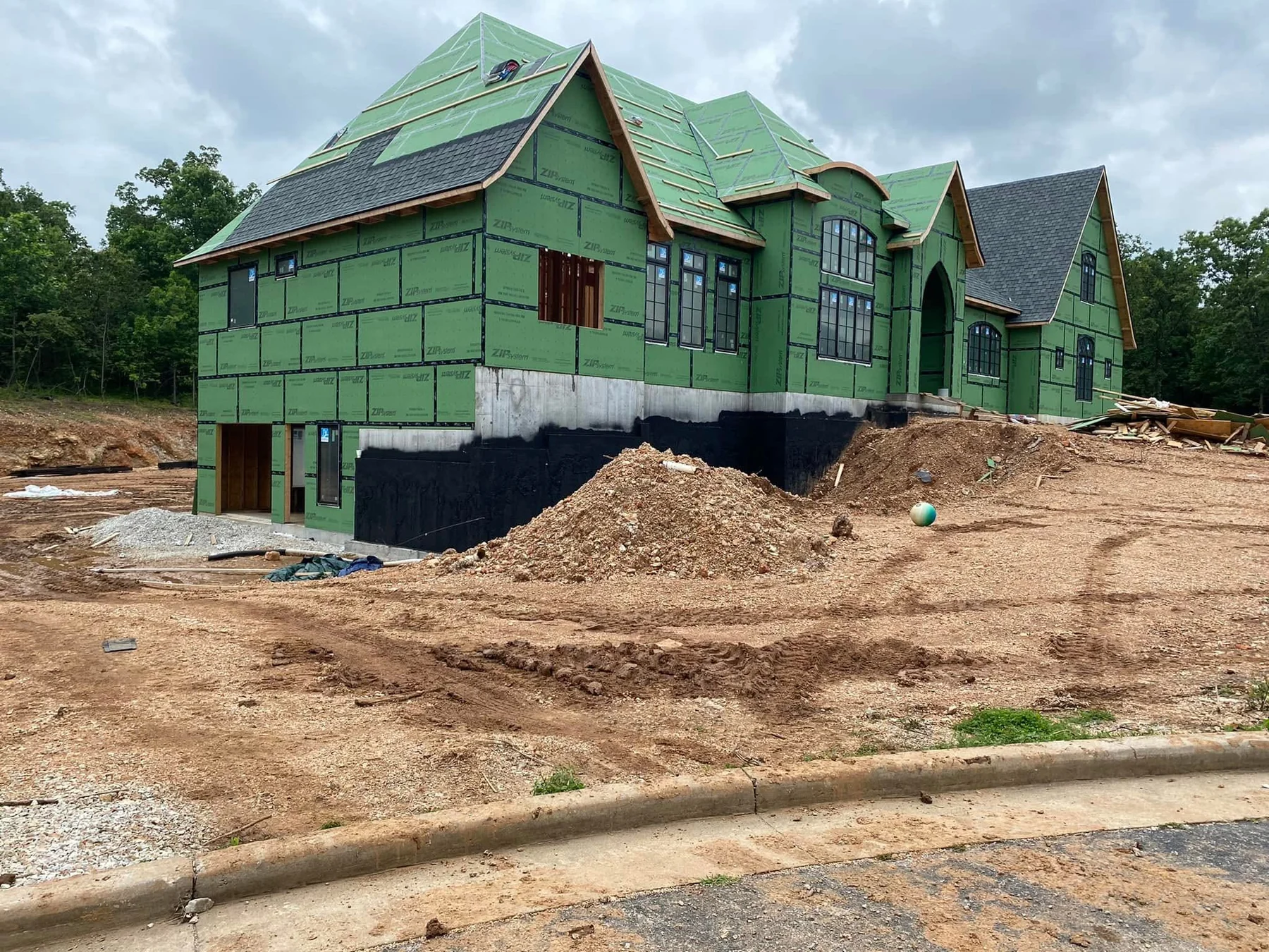 White stone custom home during construction before landscaping