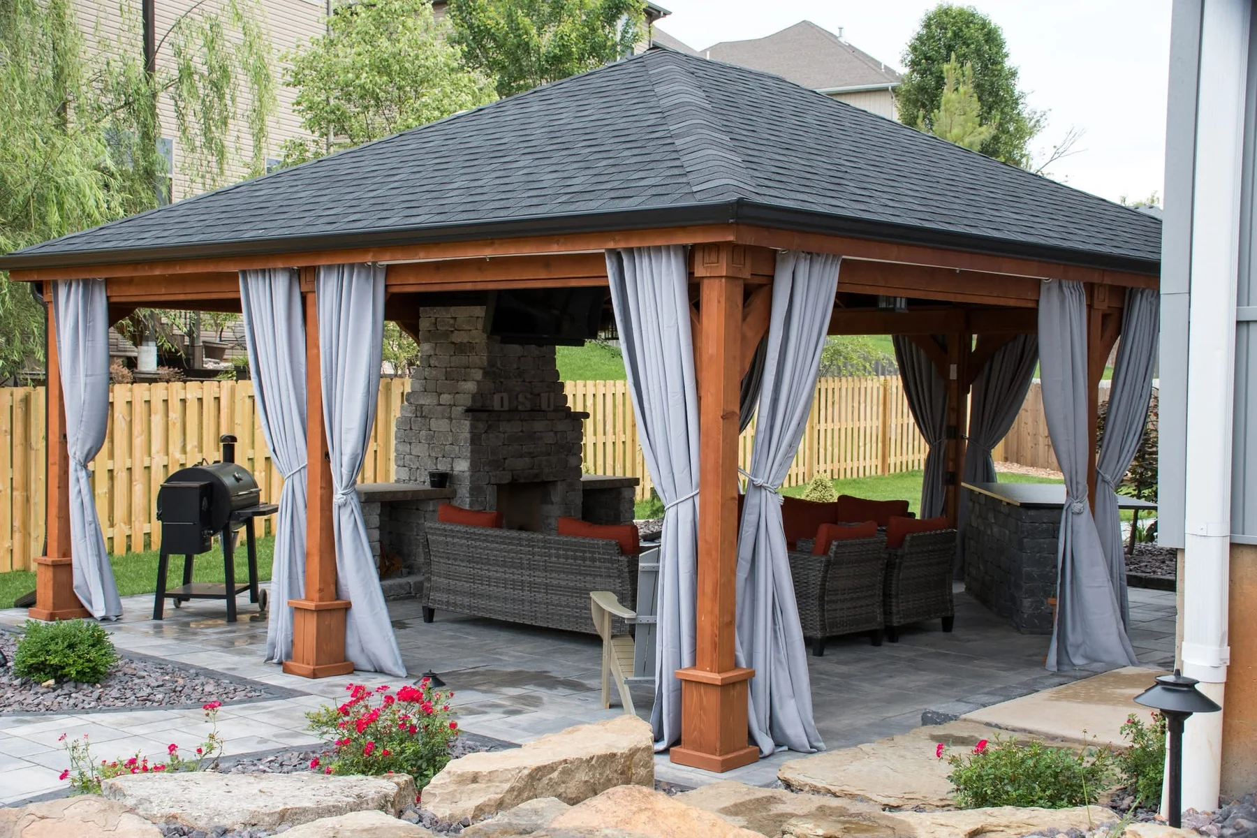 Covered outdoor living pavilion with landscaping and hardscaping
