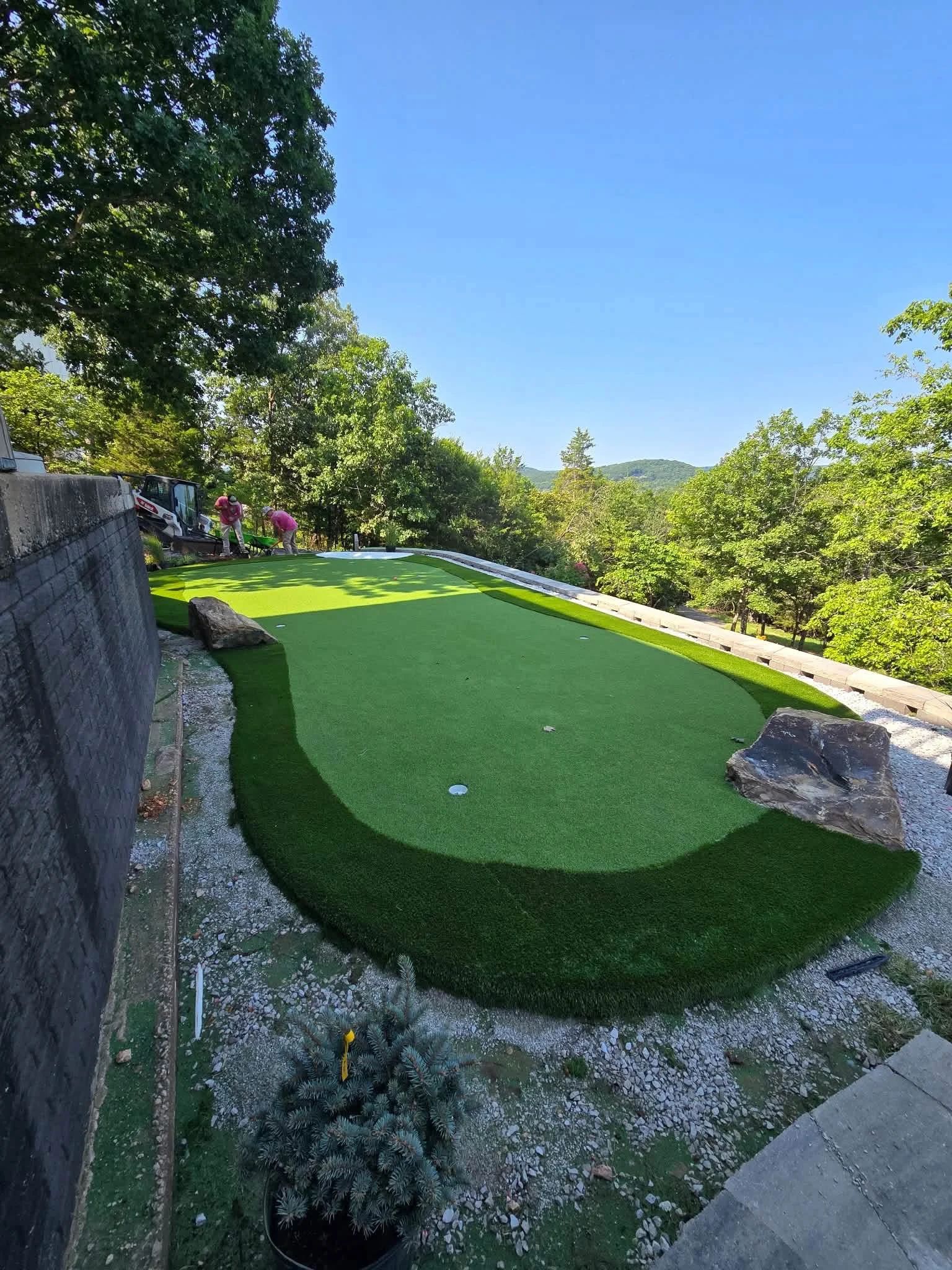 Custom backyard putting green on a sloped property